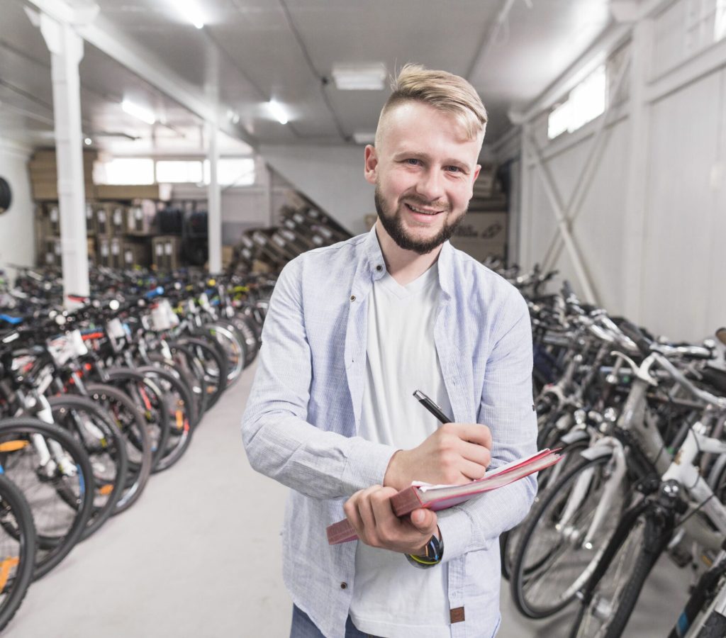 portrat-eines-schreibens-des-glucklichen-mannes-auf-dokument-im-fahrradshop(1)
